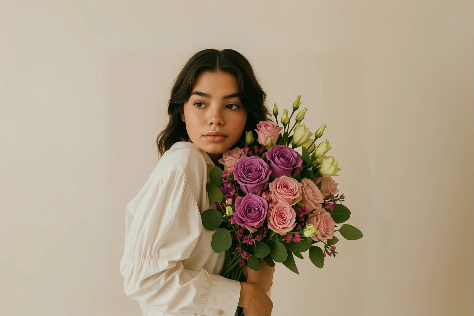 modela joven morena sosteniendo ramo Roxana con rosas rosas de persa flores