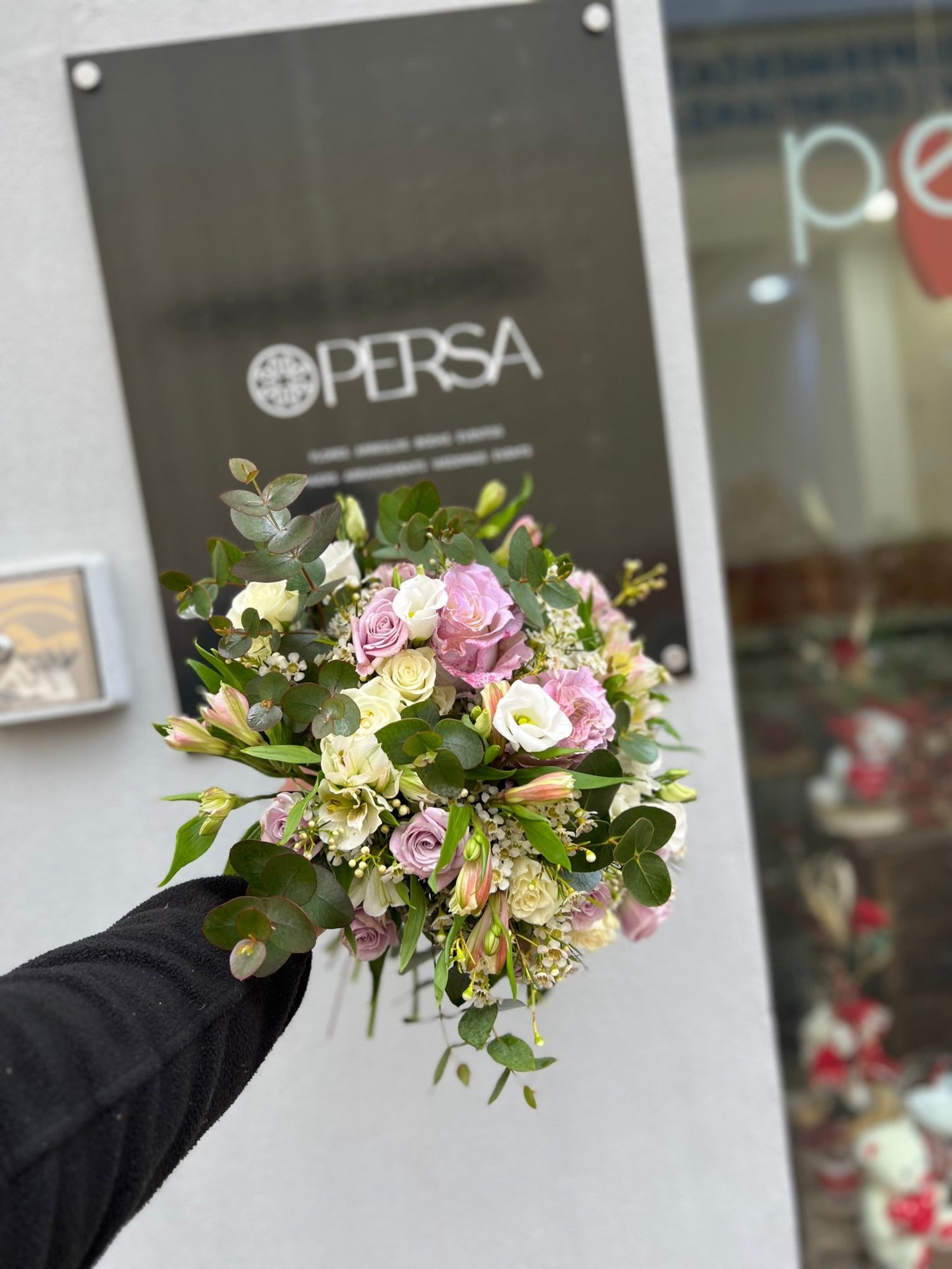Ramo de novia con el logo de Persa Flores en un fondo negro