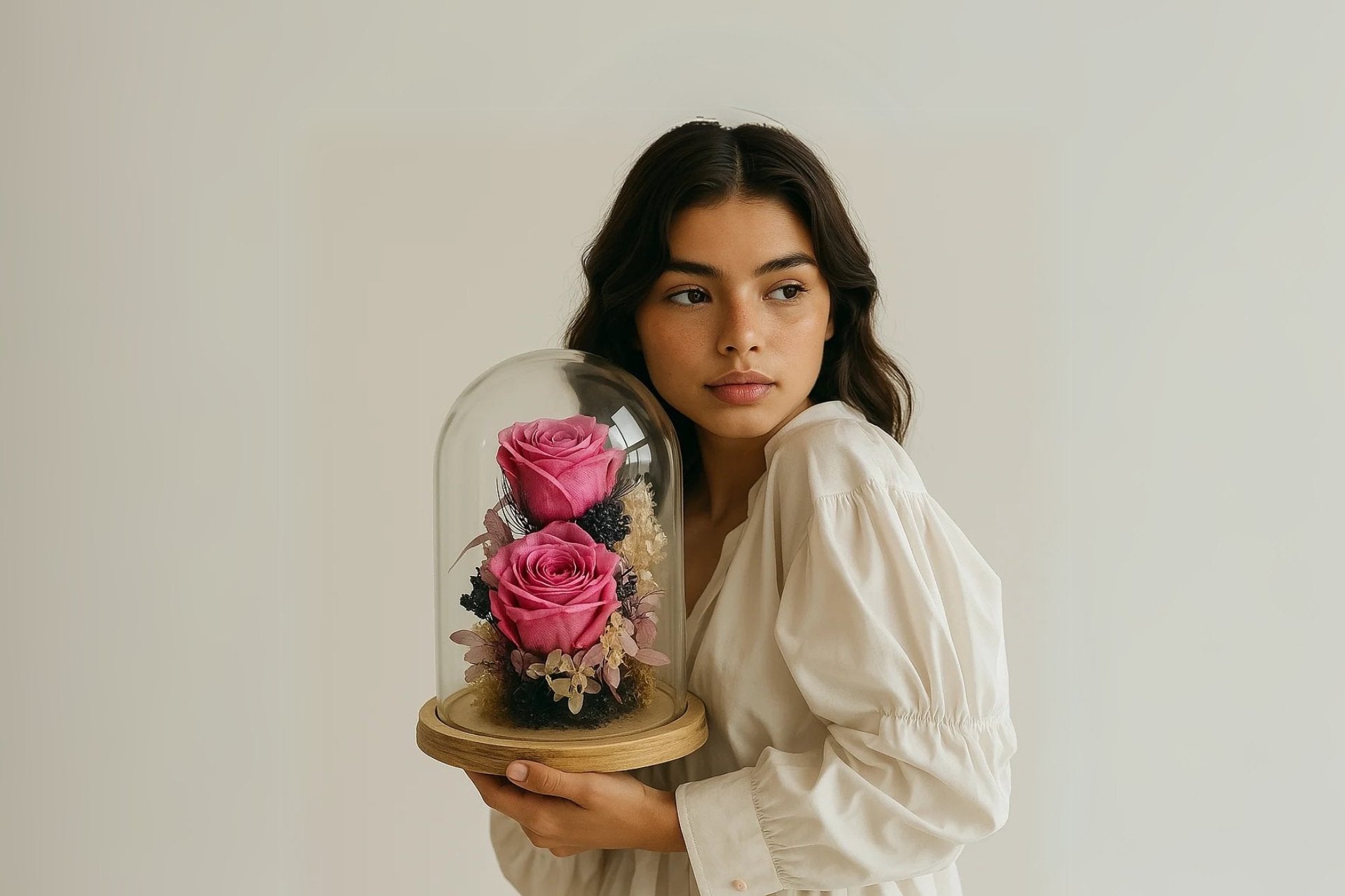 joven guapa sosteniendo el cupula de rosas preservadas de persa flores